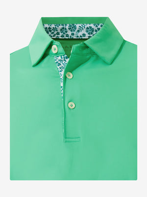 Flat lay of the folded irland green everyday classic solid polo, showcasing the neat silhouette and solid color design