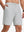 Front lower body shot of model wearing khaki grey breathable running shorts with 4 zipper pockets