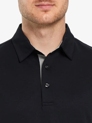 Model showcasing the black long sleeve pique polo, highlighting its sleek design and solid color.