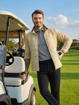 Model leaning by a golf cart on course, wearing golf fleece winter puffer jackets in light khaki outdoor setting