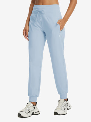 Model wearing women's stretch fleece lined water resistant joggers in light grayish blue, showcasing the front lower body view.