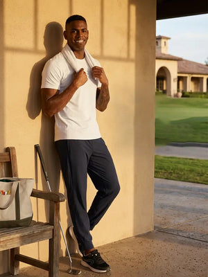 Model leaning on wall with towel smiling in Performance tapered sports joggers, relaxed navy