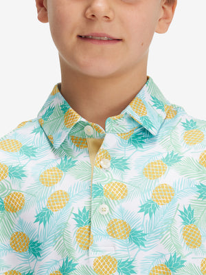 Close-up: nose to chest in leaves pineapple performance print boys golf polo