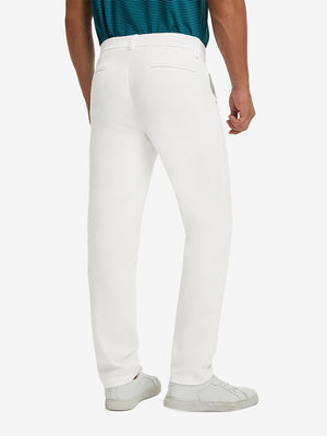 Back view of model wearing water-resistant golf stretch nylon pants, tailored stretch fit in white.