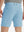 Back lower body view of model wearing the light blue stretch soft flat front dress golf shorts, highlighting the rear design