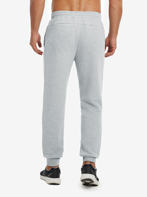 Back lower body view showing light grey heather soft sweatpants with 4 zipper pockets