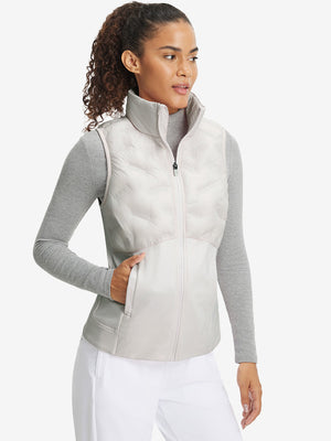 Front upper body of model wearing women's lightweight slim-fit puffer vest, sleek fit in oyster grey
