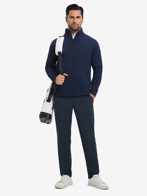 Model carrying a tennis bag, wearing water-resistant golf stretch nylon pants in navy, full front view.