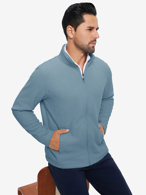 Model with both hands in pockets, wearing soft winter fleece jackets in misty blue, warm and relaxed.