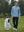 Model holding golf ball beside golf bag in classic heather pullover hoodies with 2 pocket, light blue melange