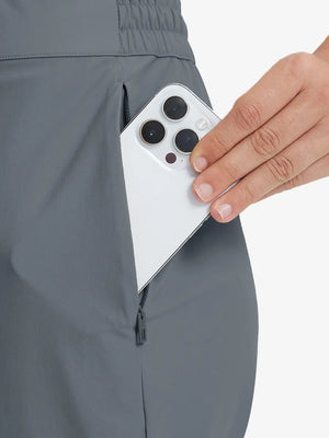 Detail shot of front side pocket holding an iPhone in DARK GREY Women's 7/8 Ankle Golf Track Pants.