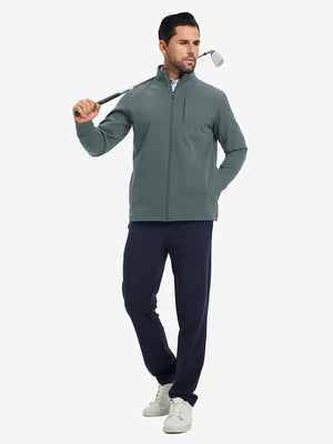 Model holding a golf club, wearing dark dusty blue water-resistant zip up golf jacket in full-body view.