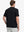 Back half-body view wearing Everyday Collarless Jersey Shirt in Black.