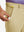 Hand placing a golf ball into pocket of water-resistant golf stretch nylon pants in khaki.