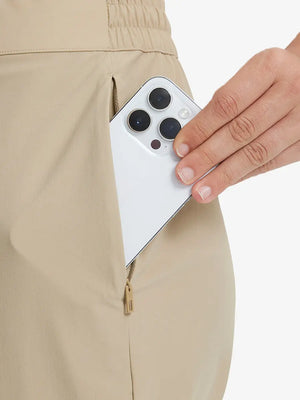 Detail shot of front side pocket holding an iPhone in Khaki Women's 7/8 Ankle Golf Track Pants.