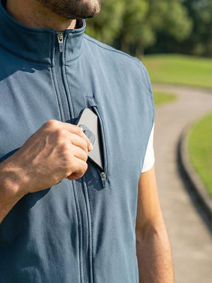 Close-up detail showing phone in the pocket of sleeveless softshell fleece outdoor vests with 6 pockets in misty blue