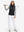 Model holding golf club full body, women's lightweight slim-fit puffer vest styled in sporty black