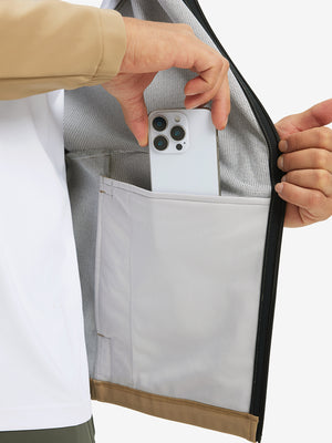 Hand placing an iPhone into pocket of water-resistant heat-tech softshell winter jacket with hood.