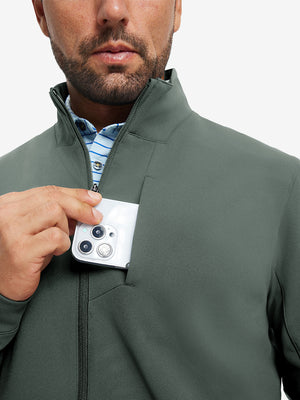 Close detail of hand in chest pocket of water-resistant zip up golf jacket in slate green.