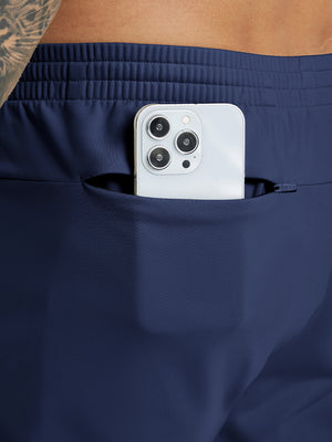 Back pocket detail of Water Resistant Comfy Fleece Golf Joggers in navy, holding smartphone