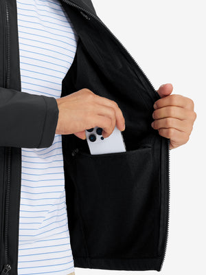 Close-up of winter thermal outdoor water resistant fleece jacket pocket holding a phone, practical detail in black