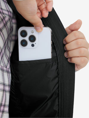Close-up of boys full-zip fleece-lined puffer vest pocket holding a phone, practical detail in black
