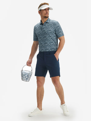 Full body model with cap holding golf bucket in Performance quick dry print golf polos, camo fragments