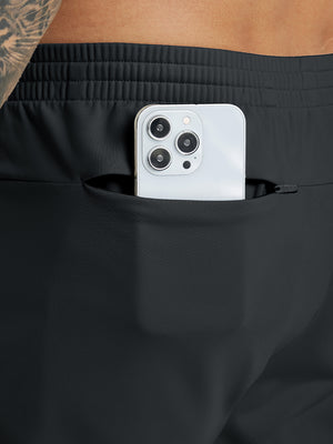 Back pocket detail of Water Resistant Comfy Fleece Golf Joggers in black, holding smartphone