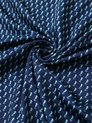 Close-up of green seahorse performance jersey print polo fabric showing breathable texture.