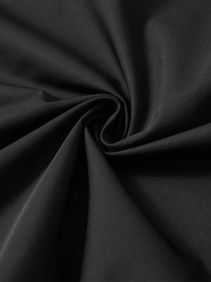 Detail of the lightweight water-repellent softshell hooded jacket in black, fabric twisted into a spiral roll.