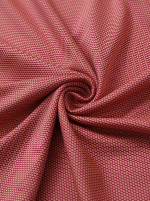 Close-up of orange performance ananas jacquard polo fabric showing refined texture.