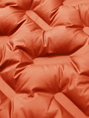 Fabric close-up of boys windproof puffer jacket with pockets, highlighting texture and finish in orange.