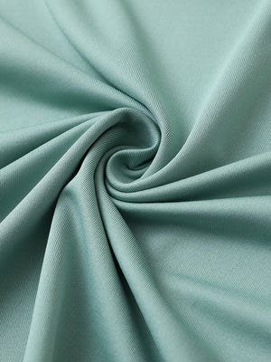 Close-up of beryl green premium performance polo fabric showing smooth texture.