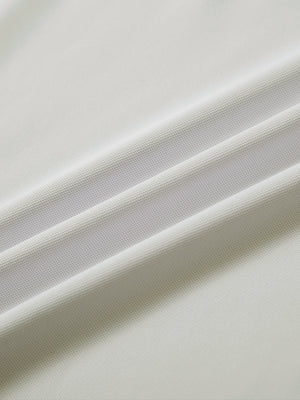 Close-up of cream long sleeve solid jersey polo fabric texture showing soft knit and smooth finish details.
