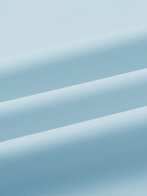 Close-up of fabric on stylish chest print snap polo, showing texture and finish in light blue.