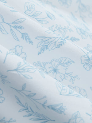 Close-up of white blue florals stretch printed collarless henley golf shirts, showcasing texture and print details.