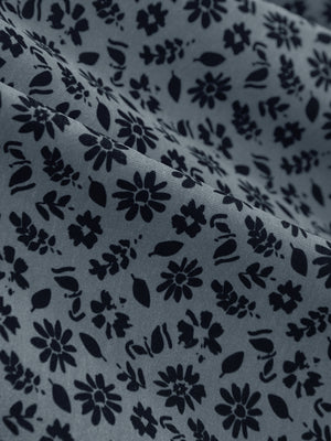 Close-up of grayish blue flower stretch printed collarless henley golf shirts, showcasing texture and print details.
