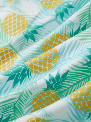 Close-up of leaves pineapple performance print boys golf polo, showcasing texture and print details.