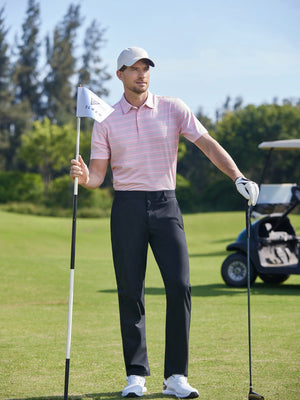Model in light pink stripe stylish stripe jersey golf polo holding a golf club outdoors, full-body shot