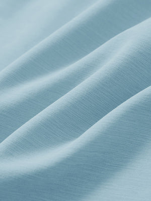 Close-up texture of light blue straight fit lightweight dress golf pants fabric showing detailed lightweight weave and material.