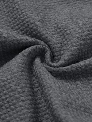 Close-up fabric detail of soft sweatpants with 4 zipper pockets, smooth texture and cozy grey heather feel