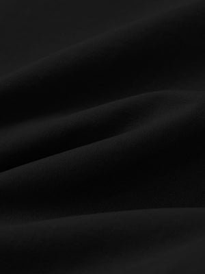 Macro view of the black youth water resistant cotton blend golf pants fabric, showcasing the water repellent surface