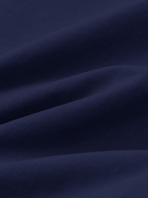 Macro view of the dark blue youth water resistant cotton blend golf pants fabric, showcasing the water repellent surface