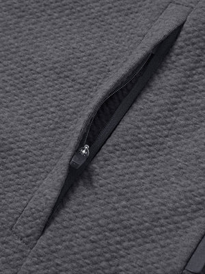 Close-up of jacket pocket showing fine stitching and insulation detail, textured insulated winter jacket, grey heather.