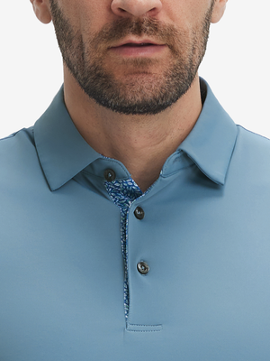 Close-up of a model wearing the misty blue everyday classic solid polo, focusing on the collar and chest area