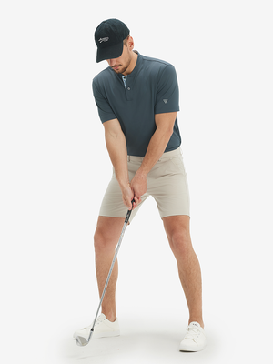 Full-body front: model in dark grey moisture-wicking short sleeve henley shirt addressing golf ball.