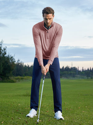 Model preparing to swing on course, wearing quarter zip melange pullover in pink heather with sporty look